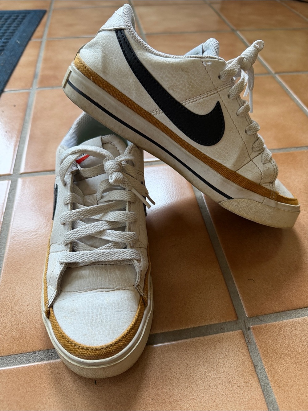 Nike Woman’s White Sneakers with Black Swoosh and Gold Trim